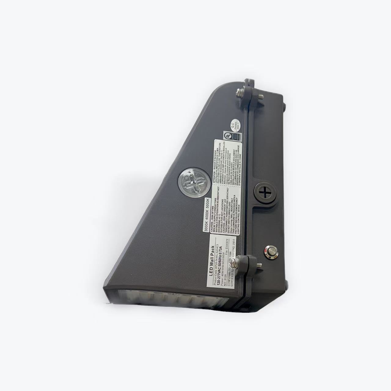 WP28 Fuu cuttoff wall pack Close-up of the WP28 series Full Cutoff Wall Pack with Emergency Battery Backup, triangular and dark grey, featuring a transparent side, labels, screws, and a plus-shaped knob for adjustments against a light grey background.
